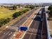 Vista aérea de uma via urbana com ciclovias, áreas verdes e circulação de veículos.