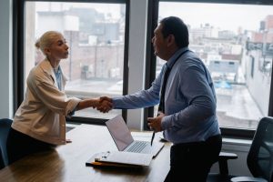 Candidata cumprimenta um empregador antes de uma entrevista de emprego em um escritório.