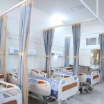 Ala hospitalar ampla e moderna, com equipamentos médicos e áreas individuais para pacientes.